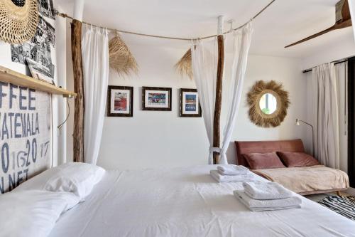 une chambre avec deux lits et un miroir dans l'établissement Studio Amar - Welkeys, à Grimaud