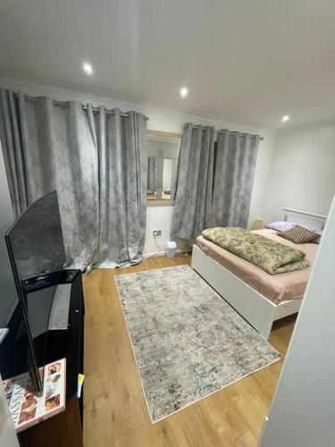 a living room with two beds and a television at 2 Bedroom House - West London in Northolt