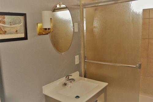 ein Bad mit einem Waschbecken, einem Spiegel und einer Dusche in der Unterkunft The Gateway in Grand Forks