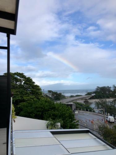 a rainbow in the sky over a road at Suítes Luxo Marambaia- Epic House in Rio de Janeiro