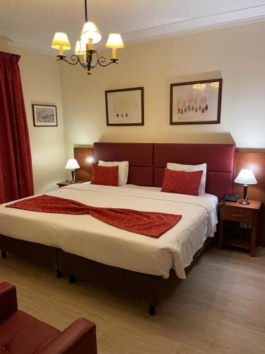 a bedroom with a large bed with red pillows at Pao de Acucar Hotel in Porto