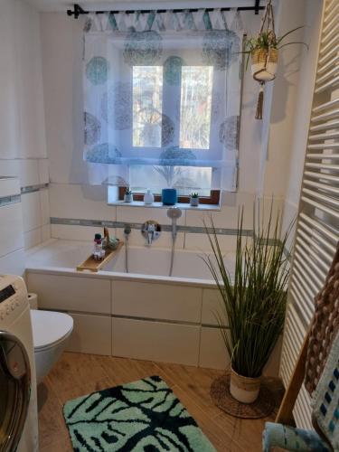 ein Bad mit einer Badewanne, einem Waschbecken und einem Fenster in der Unterkunft Am Rosengarten in Neuhaus an der Pegnitz