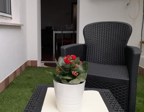 a white vase with flowers on a table next to a chair at Domus Flavia in Mantova