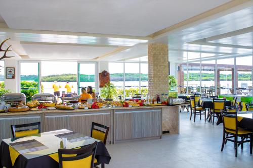 a restaurant with tables and chairs and a buffet at Pousada Jirituba in Barra de Santo Antônio