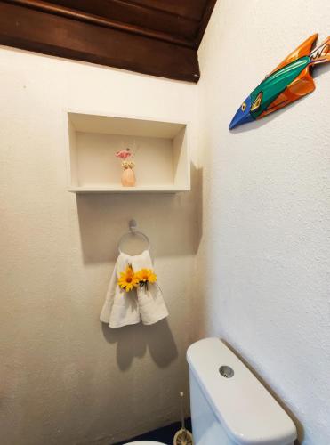 a bathroom with a toilet and a shelf with towels at Paraíso Sítio da prainha in Pipa