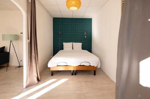 sypialnia z łóżkiem i zieloną ścianą w obiekcie Le Cosy C - T2 Tout Équipé - Centre-Ville Gare w mieście Montluçon