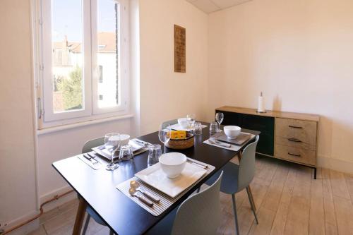 une salle à manger avec une table et des chaises noires dans l'établissement Le Cosy C - T2 Tout Équipé - Centre-Ville Gare, à Montluçon