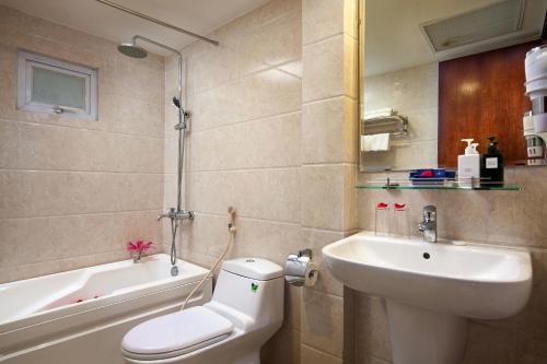 a bathroom with a toilet and a sink and a bath tub at Skyline Hanoi Hotel in Hanoi