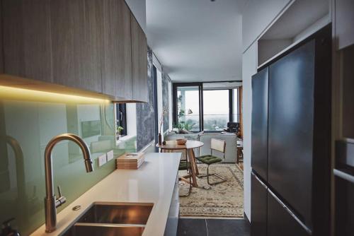 a kitchen with a sink and a table in a room at Cloud Loft Residence with 180 Degrees Views in Auckland