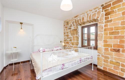 a white bedroom with a brick wall at 2 Bedroom Pet Friendly Home In Silo in Šilo