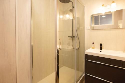 uma casa de banho com uma cabina de duche em vidro e um lavatório. em L'Urbain B - Tout équipé - Centre-Ville Gare em Montluçon