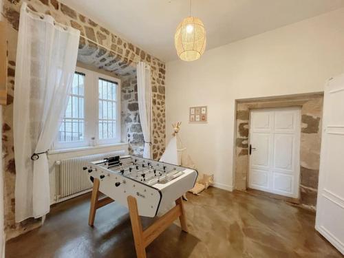 um quarto com uma mesa de matraquilhos no meio de uma sala em Logis du Chandelier em Le Puy-en-Velay