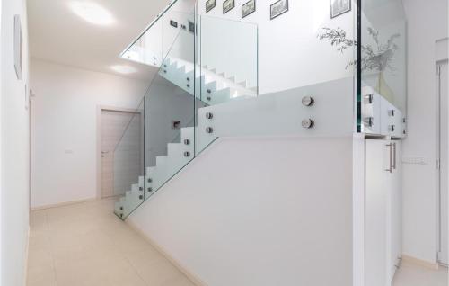 a glass staircase in a white room with a hallway at 5 Bedroom Beautiful Home In Kujici in Hreljići
