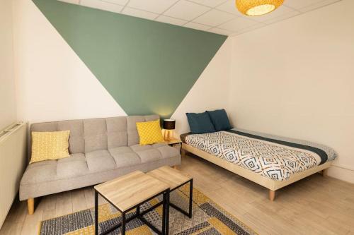 - un salon avec un canapé et un lit dans l'établissement Le Central A - Tout équipé - Centre-Ville Gare, à Montluçon