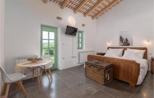 1 dormitorio con 1 cama, mesa y sillas en Awesome Home In Kojsko With Wifi, Private Swimming Pool And Heated Swimming Pool, en Kojsko