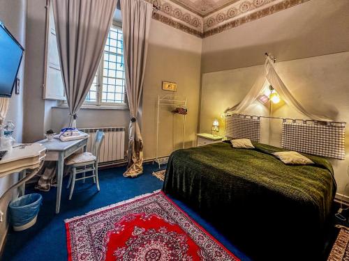 ルッカにあるGuest House Santa Giustina Lucca Centro Storicoのベッドルーム1室(ベッド1台、テーブル、窓付)