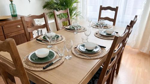 una mesa de madera con platos y copas de vino. en Le jardin secret d'Amiens Hypercentre cathédrale en Amiens