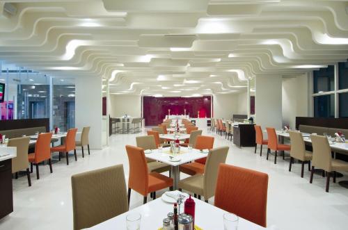 a dining room with tables and chairs and a ceiling at Keys Select by Lemon Tree Hotels, Thiruvananthapuram in Trivandrum