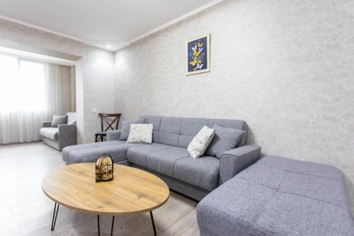 een woonkamer met een bank en een tafel bij Ninia's Apartment in Koetaisi