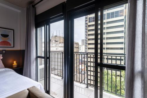 1 dormitorio con vistas a la ciudad a través de las ventanas en 91 Design studio near Paulista, en São Paulo
