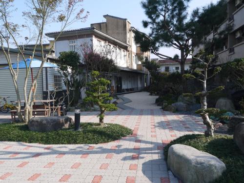a garden with rocks and trees and a building at Nature House Homestay in Dongshan