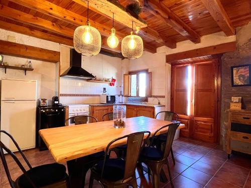 a kitchen with a wooden table and chairs at Casa Sinera in Roní
