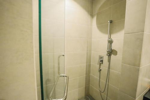 uma casa de banho com um chuveiro e uma porta de vidro em Apartment in Bukit Bintang with a clear KLCC view em Kuala Lumpur
