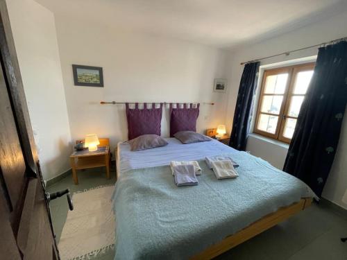 een slaapkamer met een groot bed en 2 handdoeken bij Maison au cœur de Sablet & terrasse panoramique in Sablet