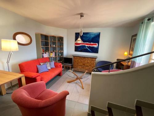 a living room with a red couch and chairs at Maison au cœur de Sablet & terrasse panoramique in Sablet