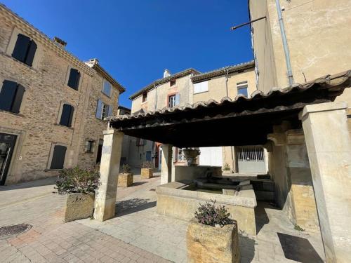 a building with a fountain in the middle of a courtyard at Maison au cœur de Sablet & terrasse panoramique in Sablet
