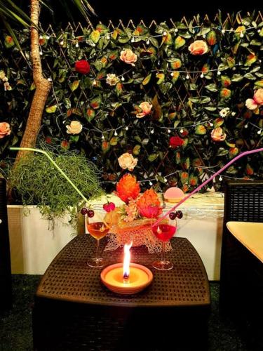 a candle on a table with two glasses and flowers at Le Stanze di Morgana intero appartam. Monterotondo in Monterotondo