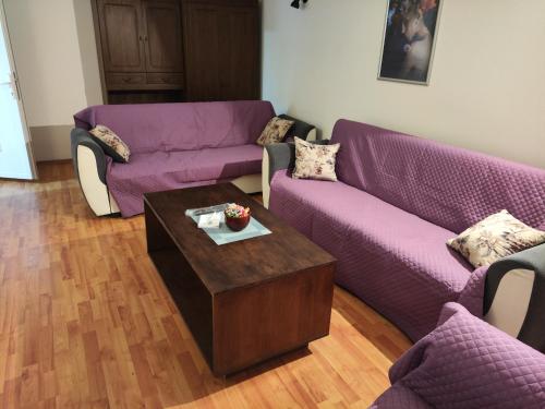 a living room with purple couches and a coffee table at Apartman Bagdala in Kruševac