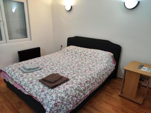 a bedroom with a bed with a blanket and a table at Apartman Bagdala in Kruševac