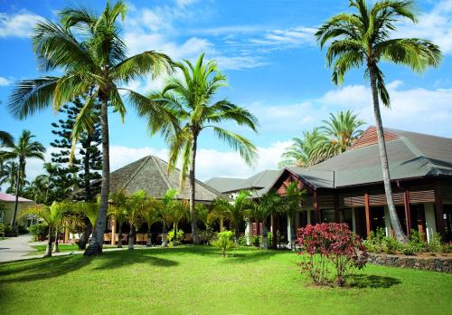 a house with palm trees in front of it at Hotel Le Recif, Ile de la Reunion in Saint-Gilles les Bains