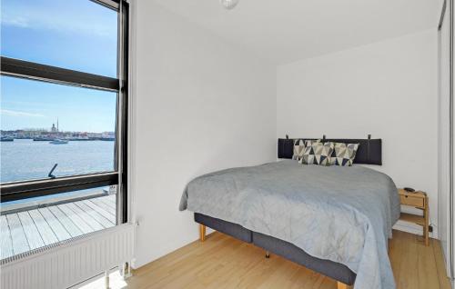 a bedroom with a bed and a large window at Amazing Apartment In Korsr With Kitchen in Korsør