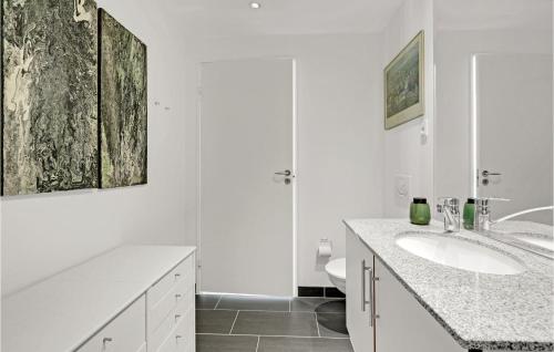 a white bathroom with a sink and a shower at Amazing Apartment In Korsør in Korsør