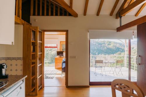 a kitchen with a door open to a patio at Quinta do Rio Gerês in Bouro