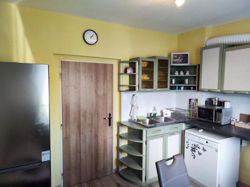 a kitchen with a sink and a clock on the wall at Veludo Apartments in Banská Bystrica