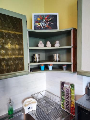 a kitchen counter with a shelf with food on it at Veludo Apartments in Banská Bystrica
