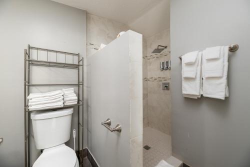 a bathroom with a toilet and a shower with towels at Home at Poinsettia Heights in Fort Lauderdale
