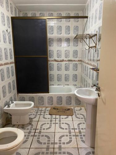 a bathroom with two sinks and a toilet and a tub at Hotel Itavera in Puerto Iguazú
