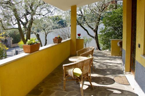 d'une terrasse avec 2 chaises et une table sur un mur jaune. dans l'établissement Sarnico giardino sul lago, à Sarnico