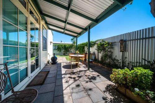 an enclosed patio with a table and chairs on it at The spotted cow,city fringe,pet friendly-Free wine in Thebarton