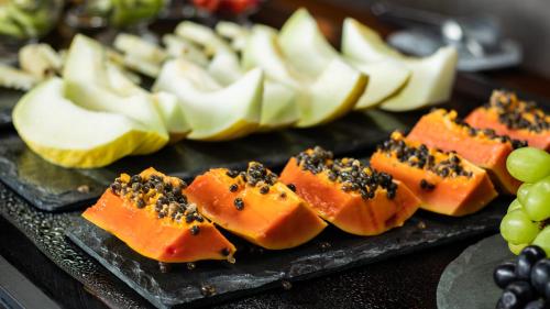 a bunch of fruit on a black plate with fruit at Hotel Savoy Excellence in Campos do Jordão