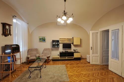 a living room with a couch chairs and a television at Demetrovics Udvarház in Eger