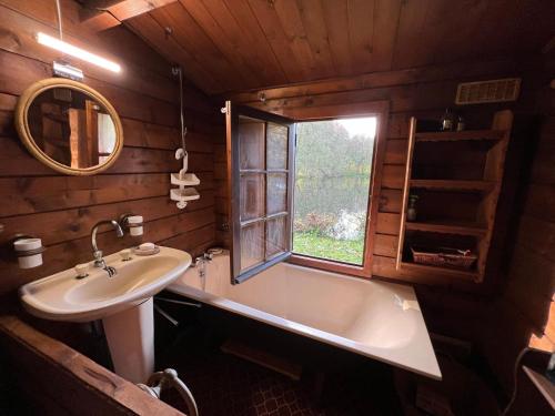 baño con lavabo, bañera y ventana en Chalet Dehault, 3 pièces, 4 personnes - FR-1-410-383, 