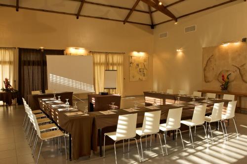 a conference room with a long table and white chairs at Hotel Le Recif, Ile de la Reunion in Saint-Gilles les Bains