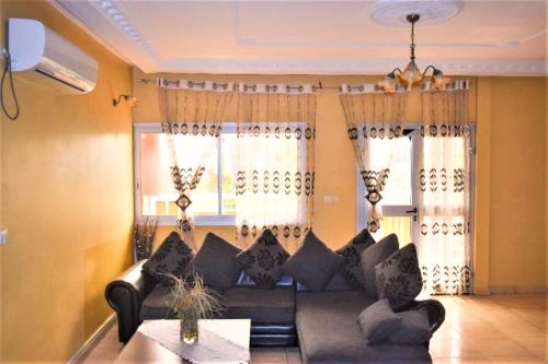 a living room with a couch and two windows at Résidence Hotelière Borel Denver in Douala