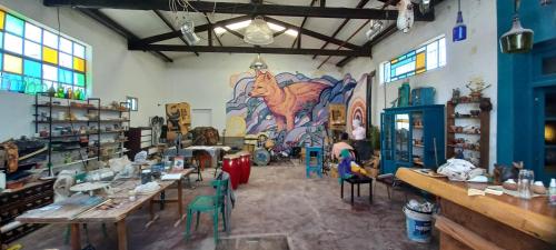 Habitación con mesas, sillas y un mural en EL Galpón en Carmen de Patagones
