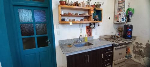 cocina con fregadero y puerta azul en EL Galpón en Carmen de Patagones